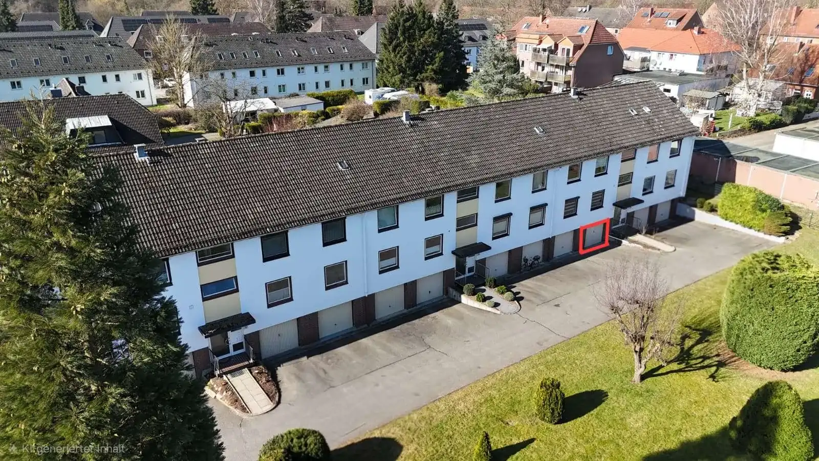 Luftaufnahme eines Mehrfamilienhauses mit Gartenanlage