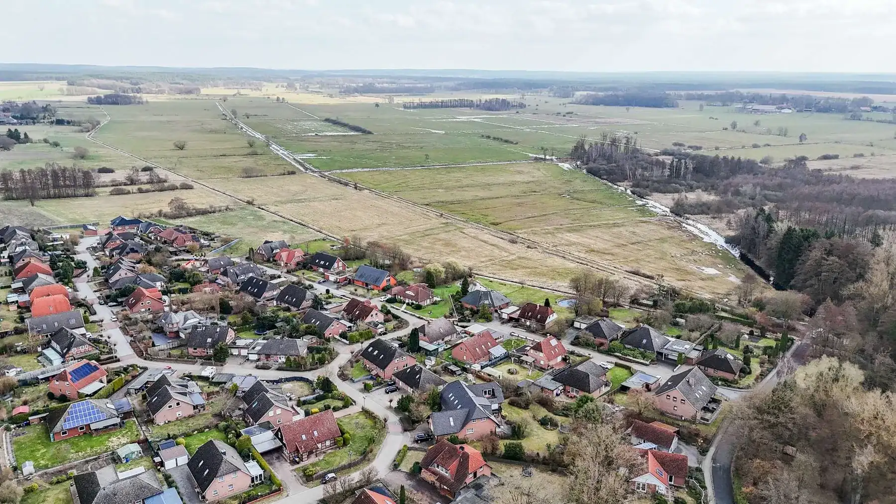 Luftaufnahme der Ortslage mit Wohnbebauung und angrenzenden Feldern