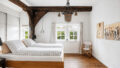Schlafzimmer im Erdgeschoss unter historischem Balkenwerk