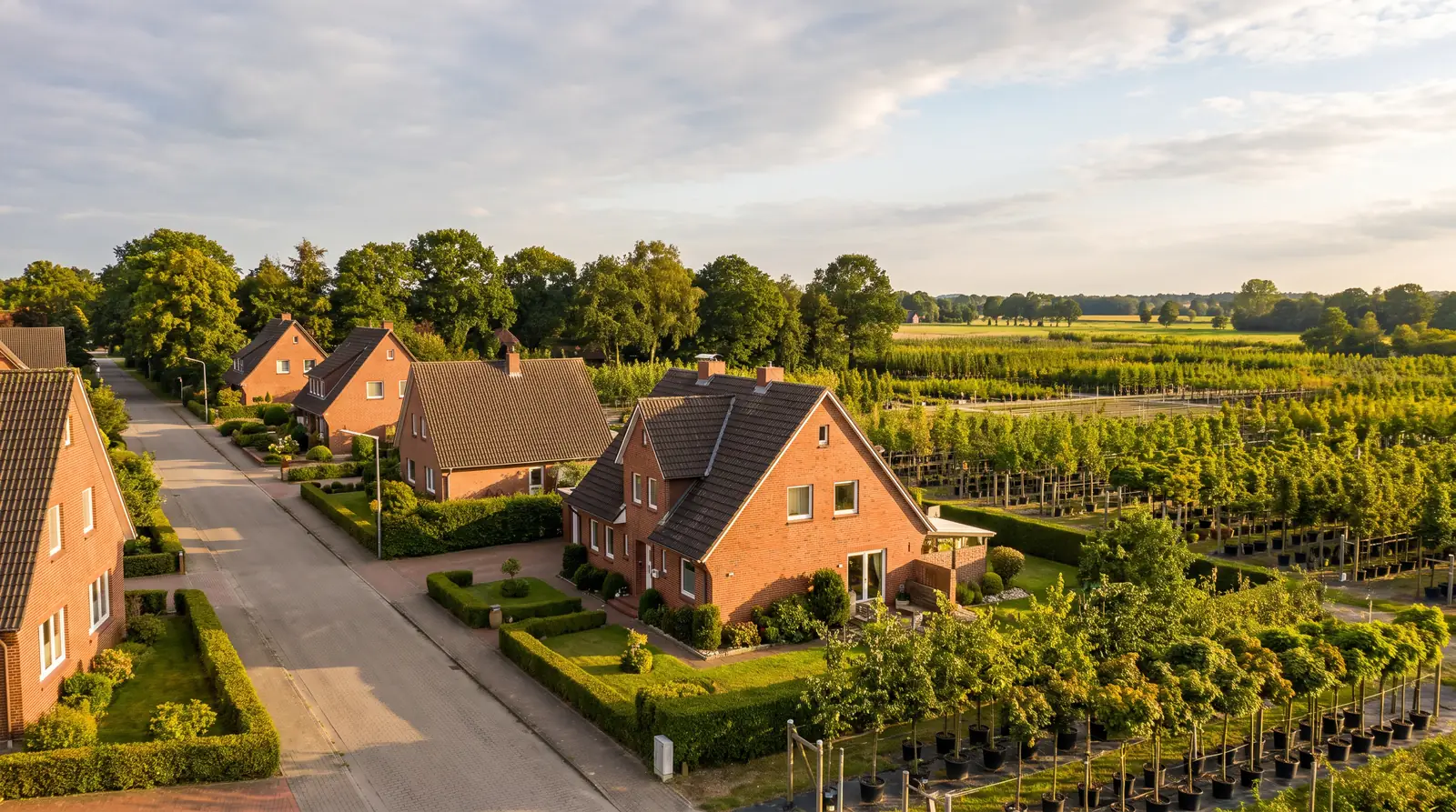 Wohnstra&szlig;e mit norddeutschen Backsteinh&auml;usern und Baumschulfl&auml;chen in Pinneberg
