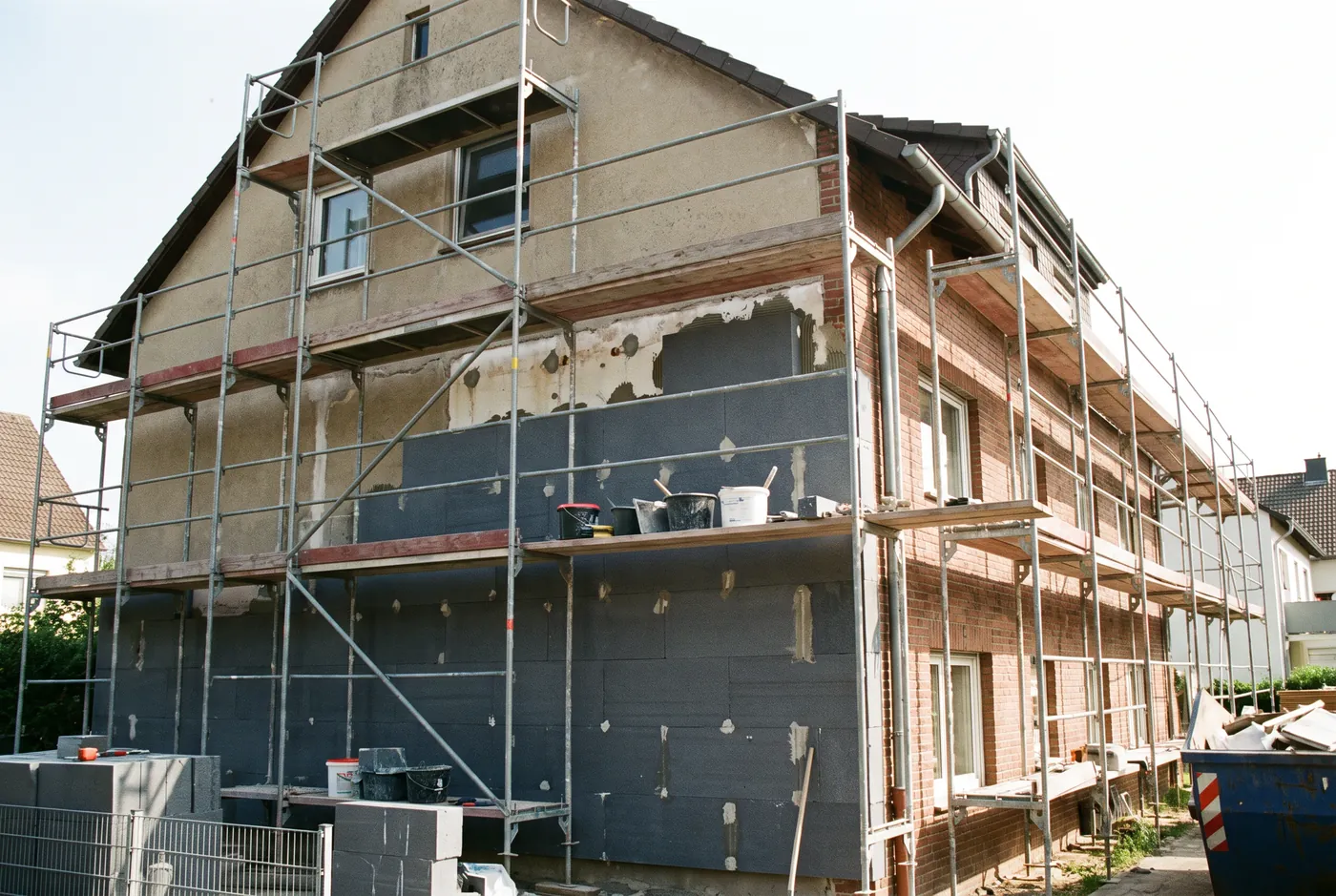 Hausfassade mit Gerüst während der Anbringung einer Außendämmung
